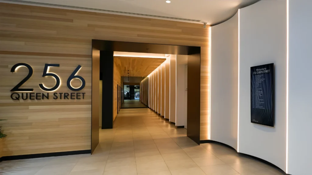Spacious modern wood panelled foyer showing S55.SP Surface Mount Digital Directory at 256 Queen Street Melbourne.