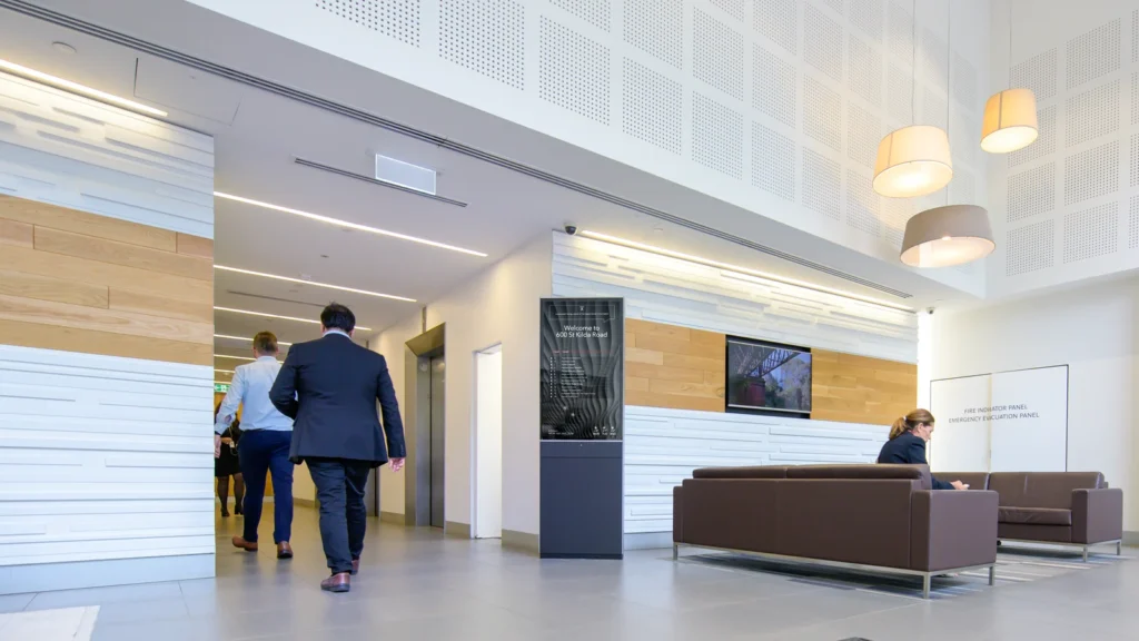 Freestanding Digital Tenant Directory Model 55FP in the lobby of 600 St Kilda Road. People relaxing and heading to work.